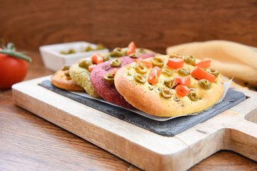 variety of different focaccia, with pumpkin, carrot and beet, on a rustic table