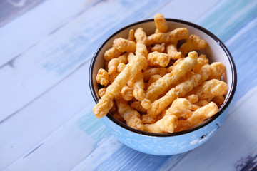 Close up of tasty chips in a bowl on table.