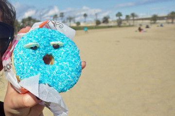 View defocused of Barcelona beach with an big donuts and anthropomorphic face who is happy....