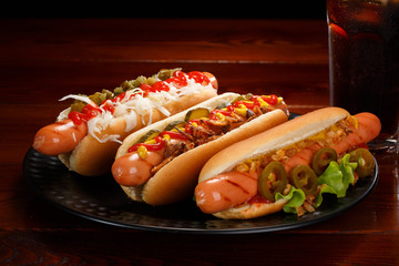 Set of various hot dogs and a glass of cola with ice.