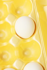 Chicken eggs in yellow packaging close up