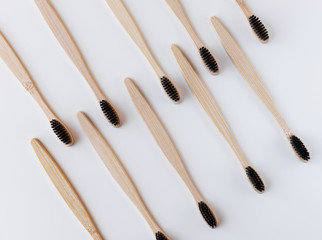 Group of black eco bamboo toothbrushes, on white background. Top view, pattern. Natural organic...