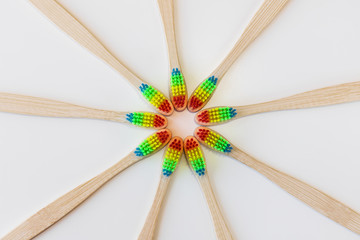 Pride concept. Rainbow bamboo toothbrushes stacked in a circle. White background. Top view. Natural organic product for oral hygiene. Dental zero waste and no plastic concept. Safe for the earth.