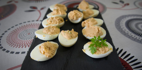 Halved eggs filled with tuna and aromatic herbs.
