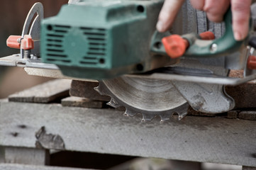 a hand circular saw cuts a board