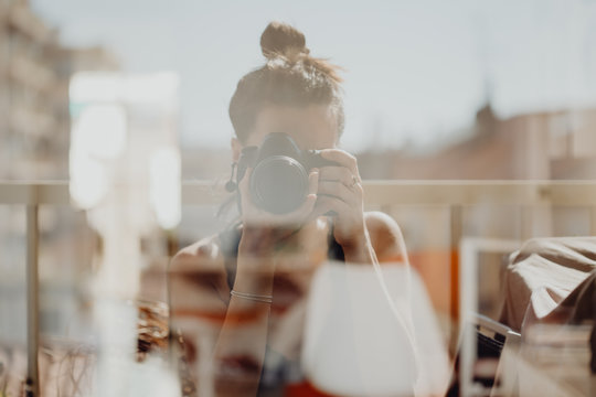 Femme se tirant le portrait dans le reflet de la vitre