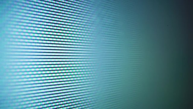 CU, macro view: moving pictures on LCD blue screen of modern TV with different glowing pixels in light room extreme closeup