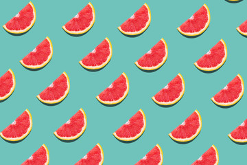 Tasty ripe grapefruit slices on blue background