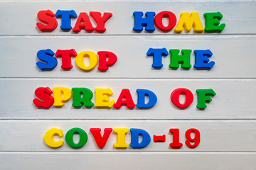 Stay home stop the spread of covid-19  Sign & Symbol, plastic letter on white wood background