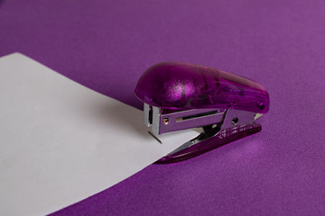 grapadora con elementos de papeleria en colores morado