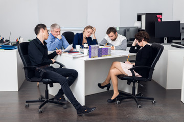 A team of five people having a meeting in the office