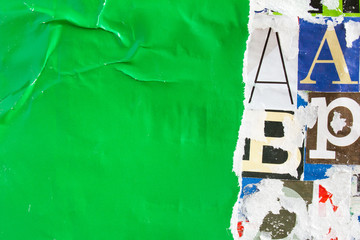 Fototapeta premium Torn crumpled and peeling green paper placard poster on colorful collage from clippings with letters and numbers texture background. Copy space for text message.