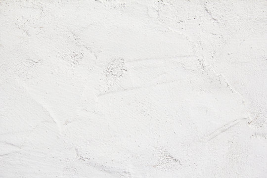 Closeup white blank plaster painted wall with rough surface texture background.