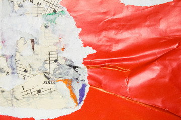 Fototapeta premium Torn and crumpled glossy red poster on old scraps of paper music sheet with notes background.