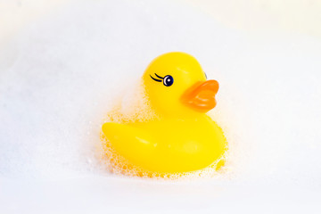 Rubber duck in the foam. minimally creative concept. bathing children