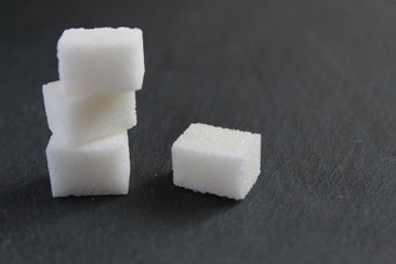 three pieces of sugar are stacked on top of each other on a gray dark black background