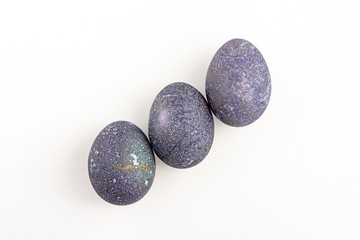 Fototapeta na wymiar 3 Blueberry colored Easter eggs