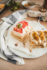 Fluffy puff pastry dessert with whipped cream and strawberries and banana