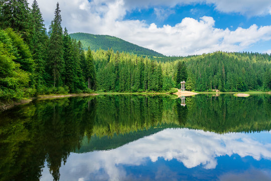 lake scenery among the forest in mountains. beautiful alpine landscape in summer. Synevyr National park is a popular destination of Ukrainian Carpathians. clouds reflecting on the calm water surface