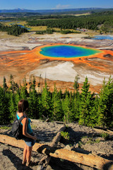 Tourist enjoying the view of Grand Prismatic Spring in Midway Geyser Basin, Yellowstone National...