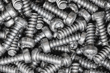 Macro concept, a lot of tapping metal or iron screws, screws as background, wallpaper or texture, industrial background