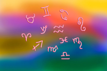 Astrological horoscope symbols on a rainbow background
