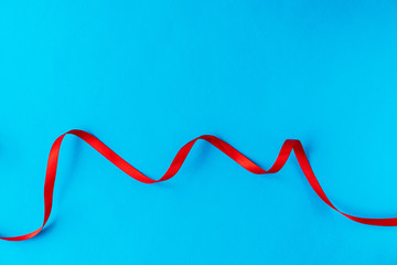 Wavy red ribbon on a blue background. A good idea for a holiday card or background for text, like a computer wallpaper or a screensaver on your phone