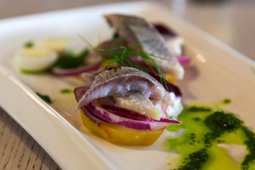 Appetizer of salted herring and potatoes closeup