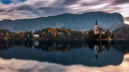 Cloudy backlit shot of of the central island with the famous church on it and the surrounding autumnal landscape at the Lake Bled, Slovenia