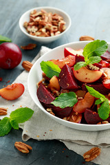 Vegan Plum, beet salad with pecan nuts, mint and herbs in white bowl. healthy summer food.