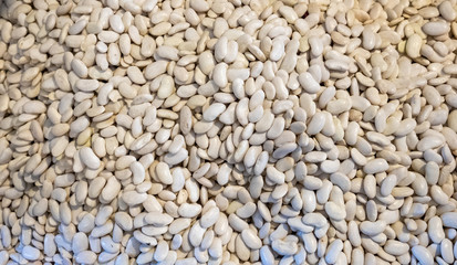 Different types of beans in a box. Legumes, multi-colored grains. Red, white, colorful fruits. Selling a crop in the market. Natural, healthy, vitamin-rich foods. Food for health.