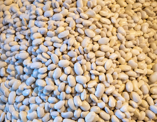 Different types of beans in a box. Legumes, multi-colored grains. Red, white, colorful fruits. Selling a crop in the market. Natural, healthy, vitamin-rich foods. Food for health.