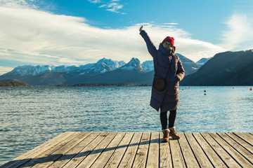 travel life style girl posing on woode pier waterfront district with sea bay and gorgeous mountain landscape background scenic view winter