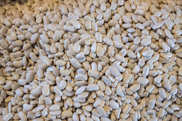 Different types of beans in a box. Legumes, multi-colored grains. Red, white, colorful fruits. Selling a crop in the market. Natural, healthy, vitamin-rich foods. Food for health.