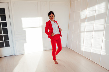 Portrait of a business woman brunette in a red business suit in the office