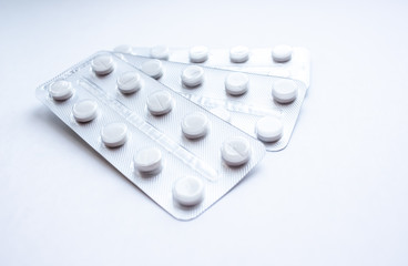 Medical pills in plastic packaging on a white background with a fan