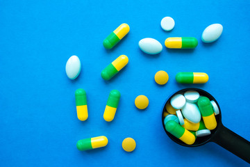 Medical drugs in a spoon on a blue background