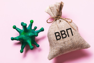 The inscription in Russian: GDP. Toy coronavirus and bag with the inscription. The concept of the impact of the covid-19 pandemic on the GDP of the Russian Federation