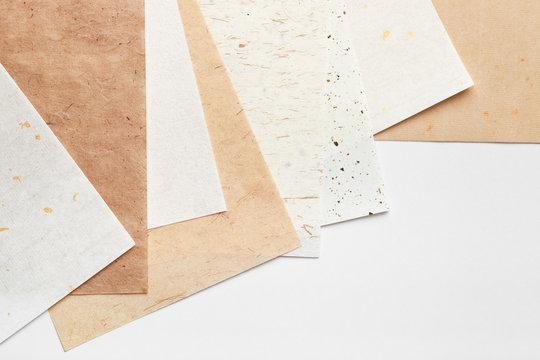 Stack of different handmade paper on a white background