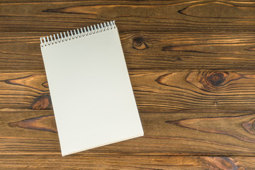 Notepad with a blank page, vintage old. On a wooden background. For design and simulation