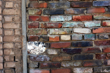 brick wall of bricks of different colors with a through hole.