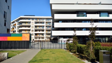 Fototapeta na wymiar Contemporary residential building exterior in the daylight. Modern apartment buildings on a sunny day with a blue sky. Facade of a modern apartment building