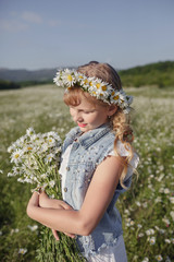 beautiful blonde teen girl in a field of daisies