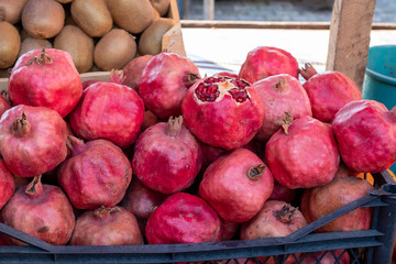 Red pomegranate in a box. Selling crops on the market. Natural, healthy, vitamin-rich foods. Food for health.