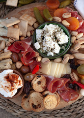 Cheese board with appetizer selection, cheese variety, cured meat, crackers, olives. Colorful meal. Top view.