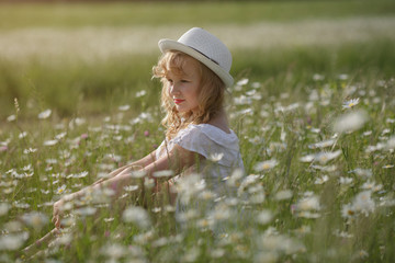 beautiful blonde teen girl in a field of daisies