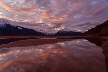 Fototapeta na wymiar Still Waters in the Chilkat Valley - The Chilkat Mountain Range at sunset is reflected in the still pools of water in the Chilkat Valley. Haines Highway, Haines, Alaska.
