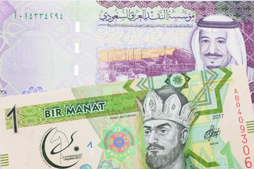 A green one manat note from Turkmenistan close up in macro with a five Saudi riyal bank note from Saudi Arabia's central bank
