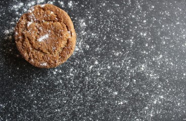 oatmeal cookies sprinkled with powdered sugar lie on a dark stand sprinkled with flour