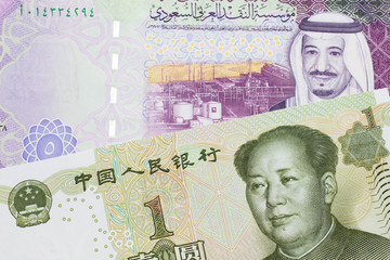 Fototapeta na wymiar A close up image of a five riyal note from Saudi Arabia along with a one yuan bank note from the People's Republic of China